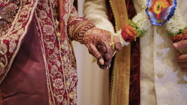 Couple standing together and holds, dressed in traditional clothes,. Close up of hands footage