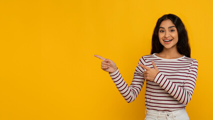 Positive beautiful young indian woman pointing at blank space