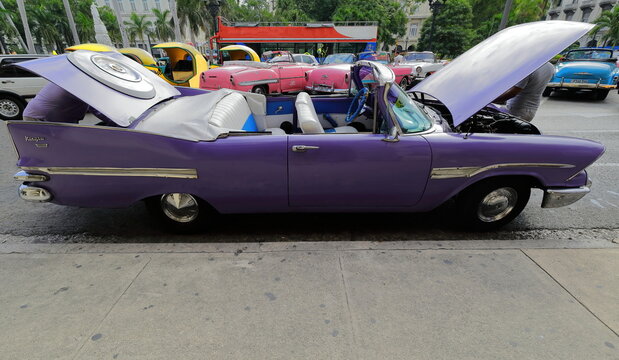 Oldtimer purplish blue almendron car -yank tank, Dodge classic- from 1959 stationed on the Paseo del Prado promenade under repair. Havana-Cuba-028