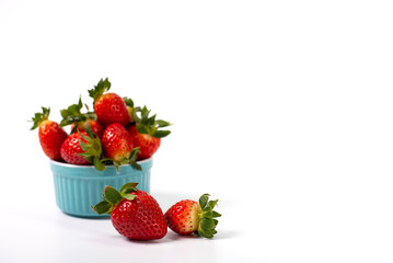 Red strawberries in a blue pial on a white background. Strawberries on a white background