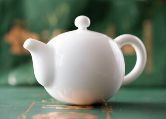 White porcelain Chinese teapot on a green background - 746798087