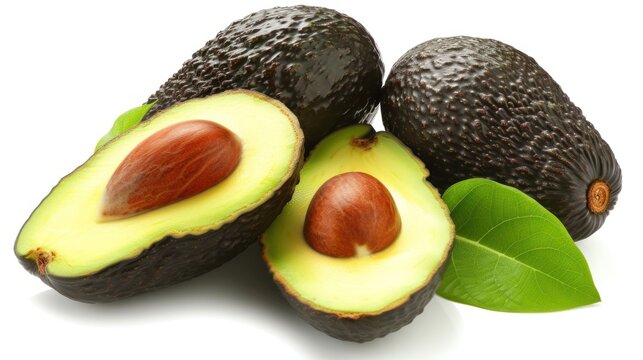 a group of avocados with one cut in half and two whole avocados with leaves on a white background.