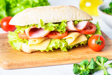 Ciabatta sandwich with lettuce, cheese, tomatoes and ham.
