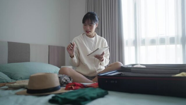 Woman checking suitcase prepare for travel at her bedroom