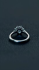 Obraz na płótnie Canvas Platinum jewelry. Product shoot, macro shot, platinum wedding ring with diamond on shiny black surface. Dark background.