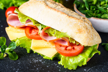 Ciabatta sandwich with lettuce, cheese, tomatoes and ham.