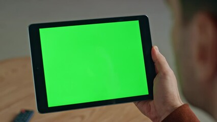 Man hand touching green tablet screen closeup. Manager holding mockup device