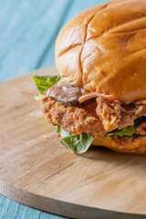 Crujiente hamburguesa de pollo apanado deliciosa con queso, tocino, lechuga, pan fresco en una...
