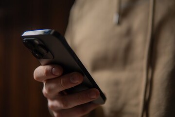 close-up of a man typing on a smartphone