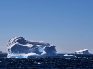 Strahlend weiße Eisberge im Antarctic Sound vor der Antarktischen Halbinsel bei fast wolkenlosem Himmel und Sonnenschein