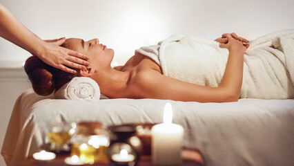 Obraz na płótnie Canvas Young girl having face massage, relaxing in spa salon
