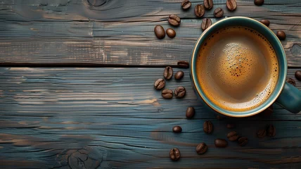 Tuinposter Top view of a cup of coffee with some coffee beens on a wooden table © daniy