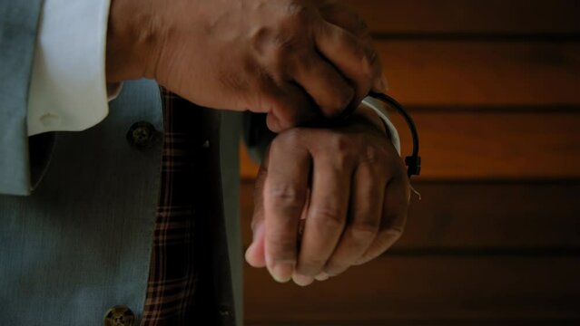 Man in suit wears a watch on his arm