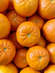 Close up of bright orange tangerines, colorful healthy fruit.