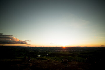 Por do sol com céu vermelho, amarelo, e sombras fortes.