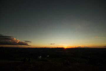 Por do sol com céu vermelho, amarelo, e sombras fortes.