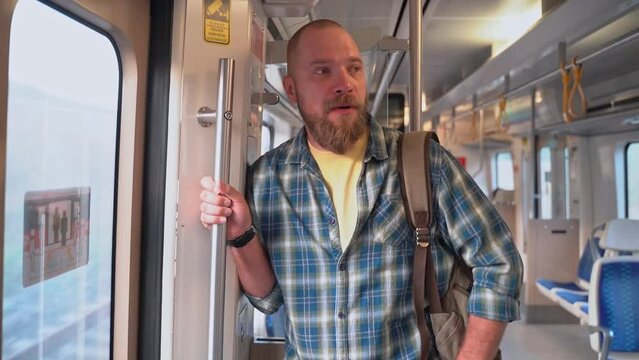 Tired man yawns, rides from work in a subway train car. Resident of suburb goes to work in the early morning by public transport. Man with backpack use metro. Adult in Public transportation.