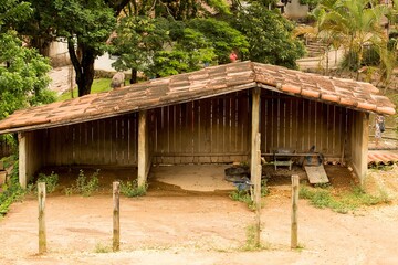 Cobertura de madeira, telha de barro e um grande terreiro em fazenda no interior de São Paulo. 