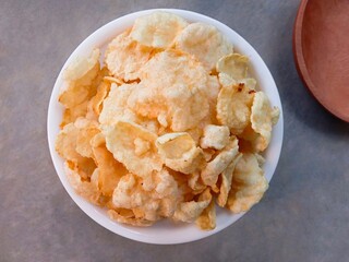bowl of cereal. Kerupuk emping or emping crackers made from melinjo seeds which are flattened, dried in the sun and then fried. Traditional crackers taste bitter and crunchy. Close up