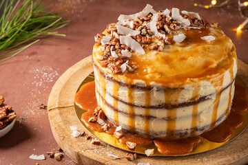 Delicious salted caramel cake with pecan nuts and coconut flakes