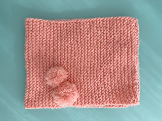 Soft pink lace knitted round scarf isolated on pastel green background. Fashion children's accessory.