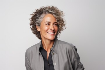 Portrait of happy mature businesswoman looking at camera over grey background