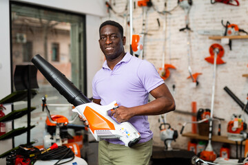 Ordinary man is buying new blower in a tool store