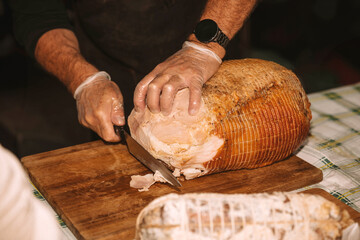 Artisan Chef Carving Slices from a Whole Roasted Ham