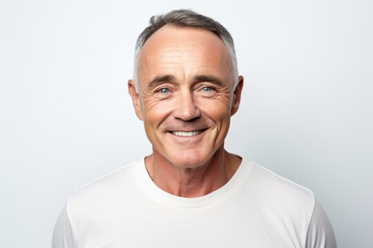 Portrait of a happy senior man smiling at the camera over grey background