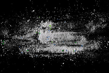 Washing white powder, dry detergent isolated on black background, top view