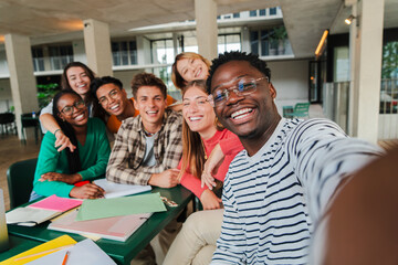 Happy young students taking a selfie portrait together at university library. African american guy shooting a photo with his smiley classmates on a high school meeting. Friends at academy. friendship - Powered by Adobe