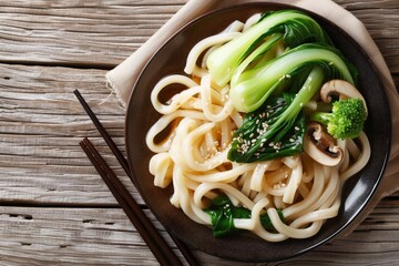 Close up view of Asian vegetarian udon noodles with baby bok choy shiitake mushrooms sesame and pepper on a table - obrazy, fototapety, plakaty