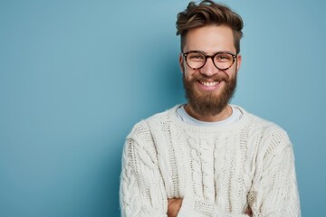 Happy young man with beard wearing casual sweater and glasses standing with arms crossed smiling at the camera Positive demeanor - obrazy, fototapety, plakaty