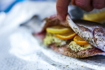 Preparing trouts with lemon, butter and dill. 