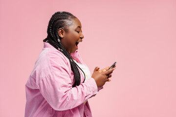 Happy African woman holding smartphone using mobile app, shopping online with sale, cash back...