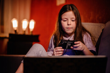 A young girl's face lights up with joy as she triumphs in a video game, capturing the excitement and engagement that gaming brings to children