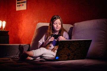 A young girl reacts while gaming, her face showing the emotional highs and lows that come with the...