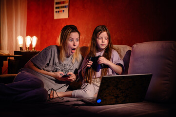 The excitement of gaming is doubled as a young girl and an adult share an exuberant moment, both...