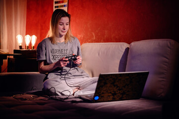 An adult gamer is engrossed in a virtual game, the soft glow of the screen illuminating her...