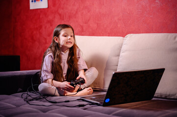 A young girl reacts while gaming, her face showing the emotional highs and lows that come with the...
