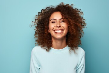 Portrait of a beautiful young african american woman with curly hair on blue background