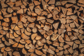 Ein Stapel gespaltetes Brennholz in der Sonne beim trocknen. Der nachwachsende Rohstoff liefert Wärme und Energie.