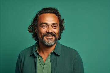 Portrait of a bearded Indian man in a green shirt on a green background