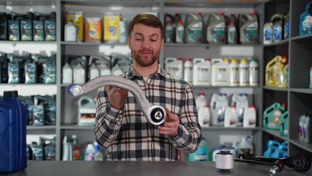 Funny auto parts seller with car spare part in shop