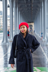 Obraz premium Young beautiful happy woman in red French beret in Paris, France against Eiffel Tower. European tourism and travels to the capital cities