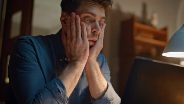 Nervous employee looking computer screen in night home closeup. Work problems