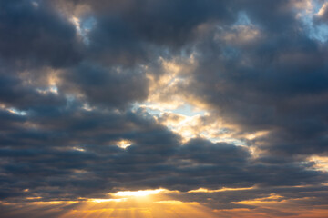Mysterious sunlight illuminates the ground through gaps in the clouds