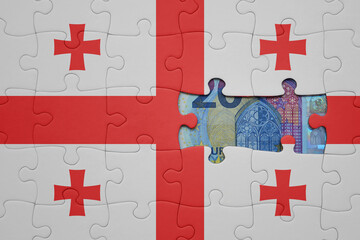 Fototapeta premium puzzle with the national flag of georgia and euro banknote. finance concept
