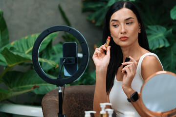 Young woman making natural beauty and cosmetic tutorial on green plant garden video content for...