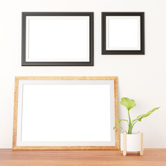 two random dark frames on the wall and a large wooden frame